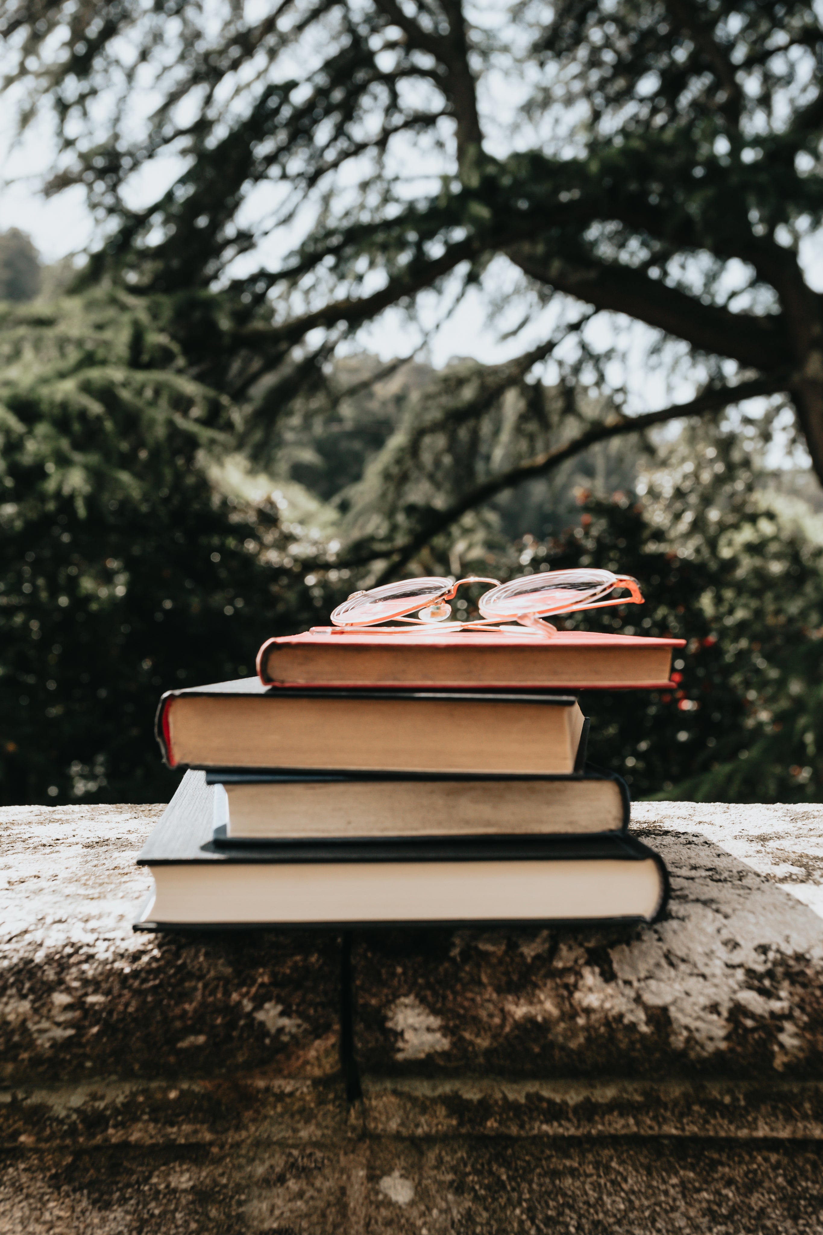 a-stack-of-hardcover-books-outdoors-with-glasses.jpg